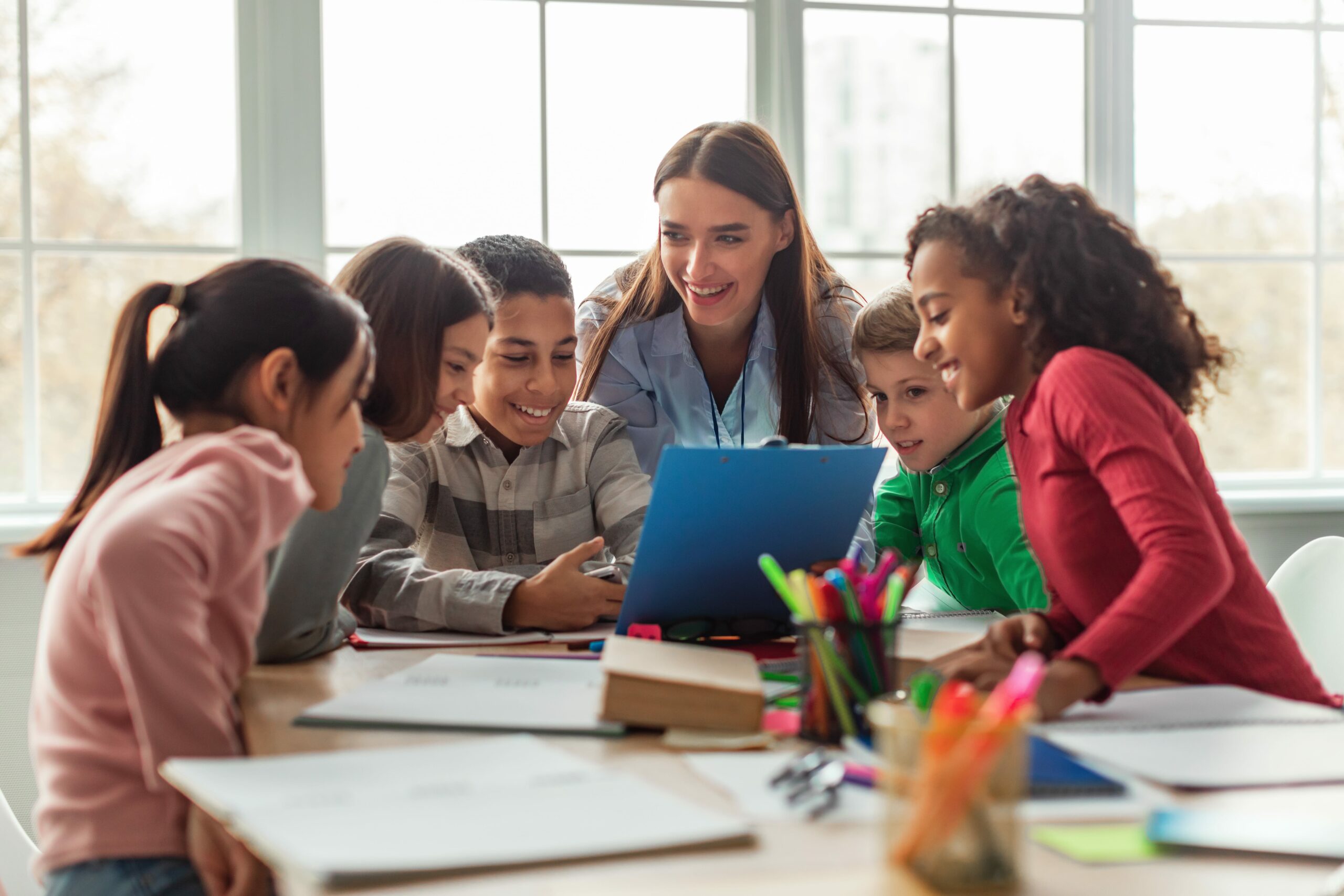 Diverse School Children And Teacher Woman Having Class In Classroom